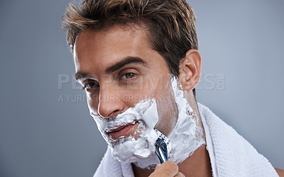 Buy stock photo Man, blade and shaving beard in studio closeup for grooming, skincare and portrait by grey background. Person, model and self care with cream, facial hair removal and product for cosmetic change