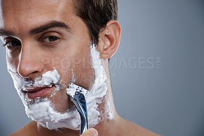 Buy stock photo Man, blade and shaving in studio portrait for wellness, skin or grooming with cream by grey background. Person, model and closeup with beard, facial hair removal and foam product for cosmetic change