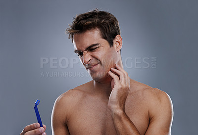 Buy stock photo Man, shaving and beard or razor burn in studio for hair removal mistake, inflammation or grey background. Male person, tool and leaning or unhappy accident for wellness maintenance, pain or mockup