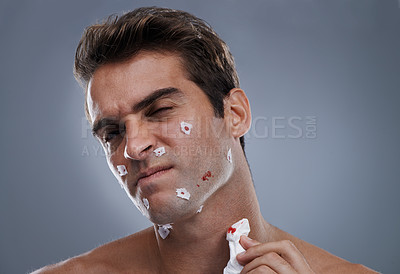 Buy stock photo Man, face and shave cuts for cleaning or hair removal hygiene or injury with blood, tissue or maintenance. Male person, grey background and dermatology with beard or health, studio or mockup space