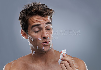 Buy stock photo Man, face and shave cuts or paper for hair removal hygiene or injury with blood, tissue or maintenance. Male person, grey background and dermatology with beard or clean health, studio or mockup space
