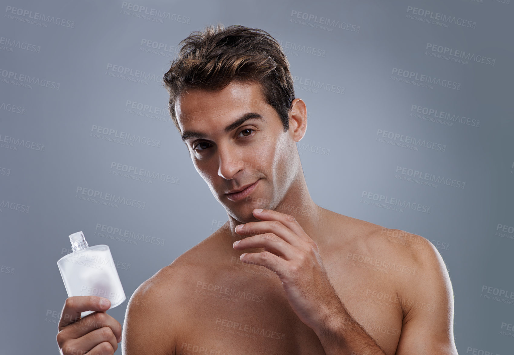 Buy stock photo Studio, portrait and man with aftershave for skincare, grooming and facial treatment or cologne. Model, face and happy with bottle for cosmetics product, fragrance and male beauty by gray background