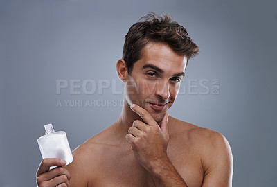 Buy stock photo Studio, portrait and model with aftershave for skincare, grooming and facial treatment or cologne. Man, face and happy for bottle for cosmetics product, fragrance and male beauty by gray background