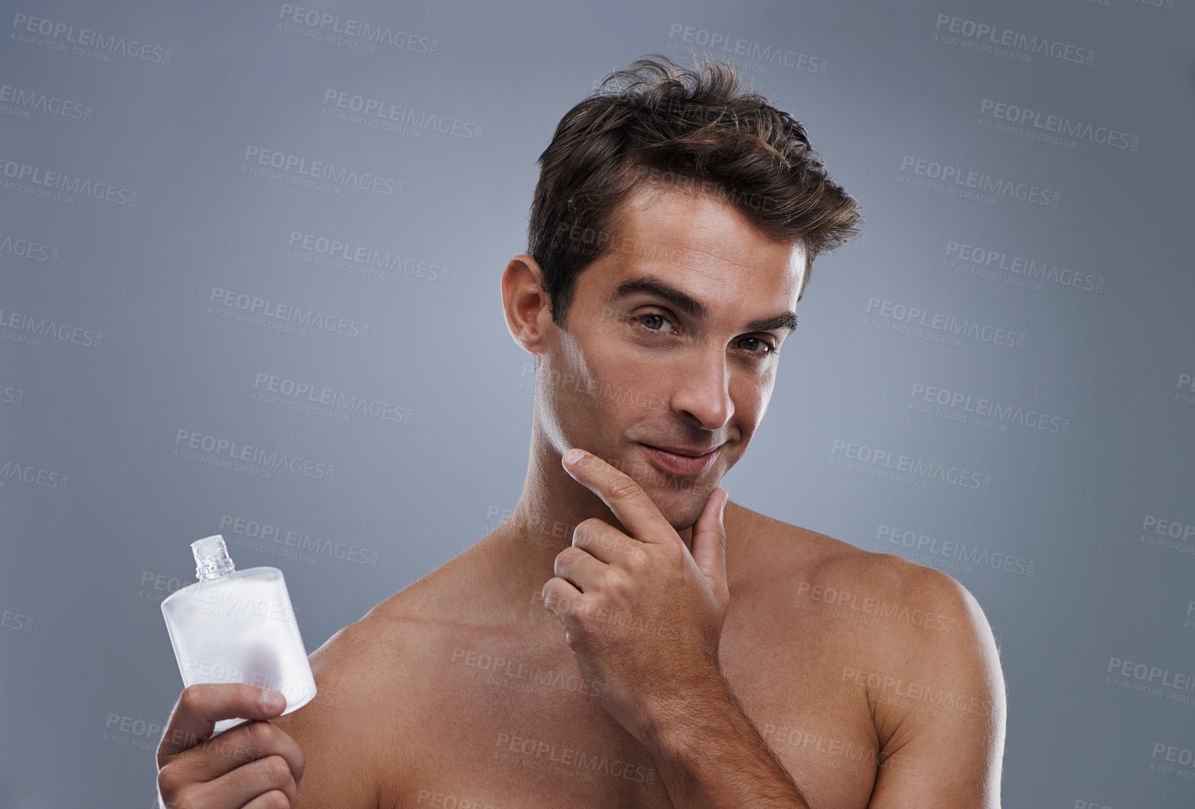 Buy stock photo Studio, portrait and model with aftershave for skincare, grooming and facial treatment or cologne. Man, face and happy for bottle for cosmetics product, fragrance and male beauty by gray background