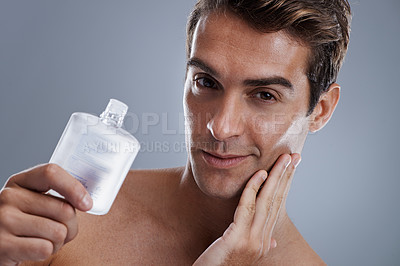 Buy stock photo Studio, portrait and man with aftershave for beauty, grooming and facial treatment or cologne. Model, face and happy with bottle for cosmetics product, fragrance and male skincare by gray background