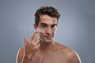 Buy stock photo Portrait, cream and man with skincare, shine and beauty with glow on grey studio background. Apply, person and model with morning routine or treatment with lotion or moisture with wellness or face