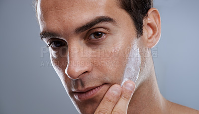 Buy stock photo Portrait, cream and man with skincare, dermatology or wellness on grey studio background. Portrait, person or model with grooming routine or treatment with lotion or moisture with glow or smooth skin