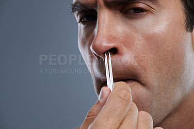 Buy stock photo Nose, hair removal and portrait of man closeup with pain from cleaning with tweezers in studio background. Beauty, epilation and person with grooming routine and treatment for self care with tools