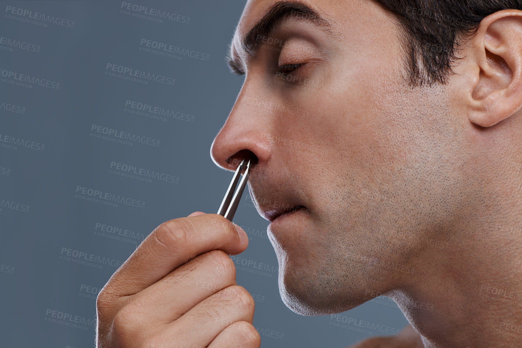 Buy stock photo Nose hair, cleaning and man with tweezers and pain from plucking in studio background or mockup. Beauty, epilation and person with facial grooming routine and treatment for self care with tools