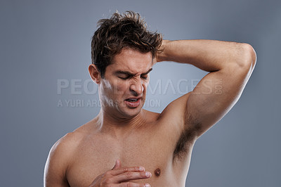 Buy stock photo Armpit, stink and man with body odor, poor hygiene and routine on grey studio background for deodorant, cleaning and skincare. Underarm, bad smell and model with hyperhidrosis, sweating or cosmetics