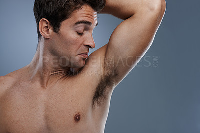 Buy stock photo Armpit, stink and man with poor hygiene, cosmetics and routine on grey studio background for deodorant, cleaning and skincare. Underarm, bad smell and model with hyperhidrosis, sweating and gross