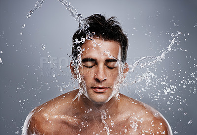 Buy stock photo A young man splashing water on his face