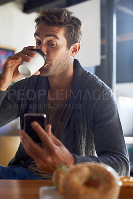 Buy stock photo Phone, drinking and man with coffee at restaurant networking on social media, mobile app or internet. Research, technology and young male person reading on cellphone with cappuccino at cafe.