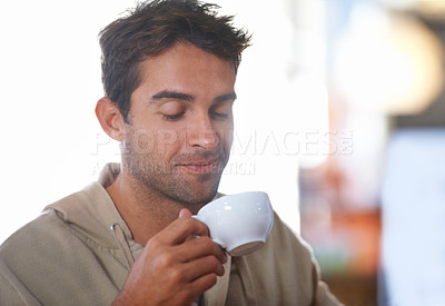 Buy stock photo Smile, coffee and young man in a cafe with positive, good and confident attitude in morning. Happy, cappuccino and male person drinking caffeine, espresso or latte beverage in mug at restaurant.
