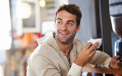 Buy stock photo Shot of a handsome young man drinking a coffee in a cafe