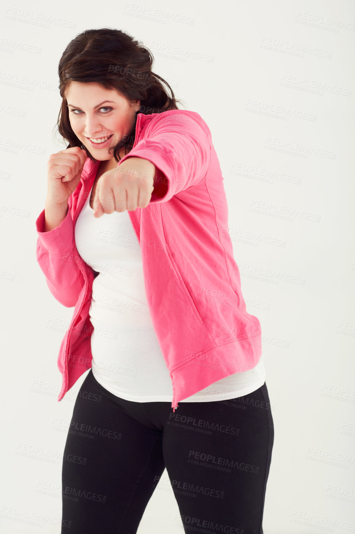 Buy stock photo Studio shot of a young woman throwing punches while wearing exercise clothing