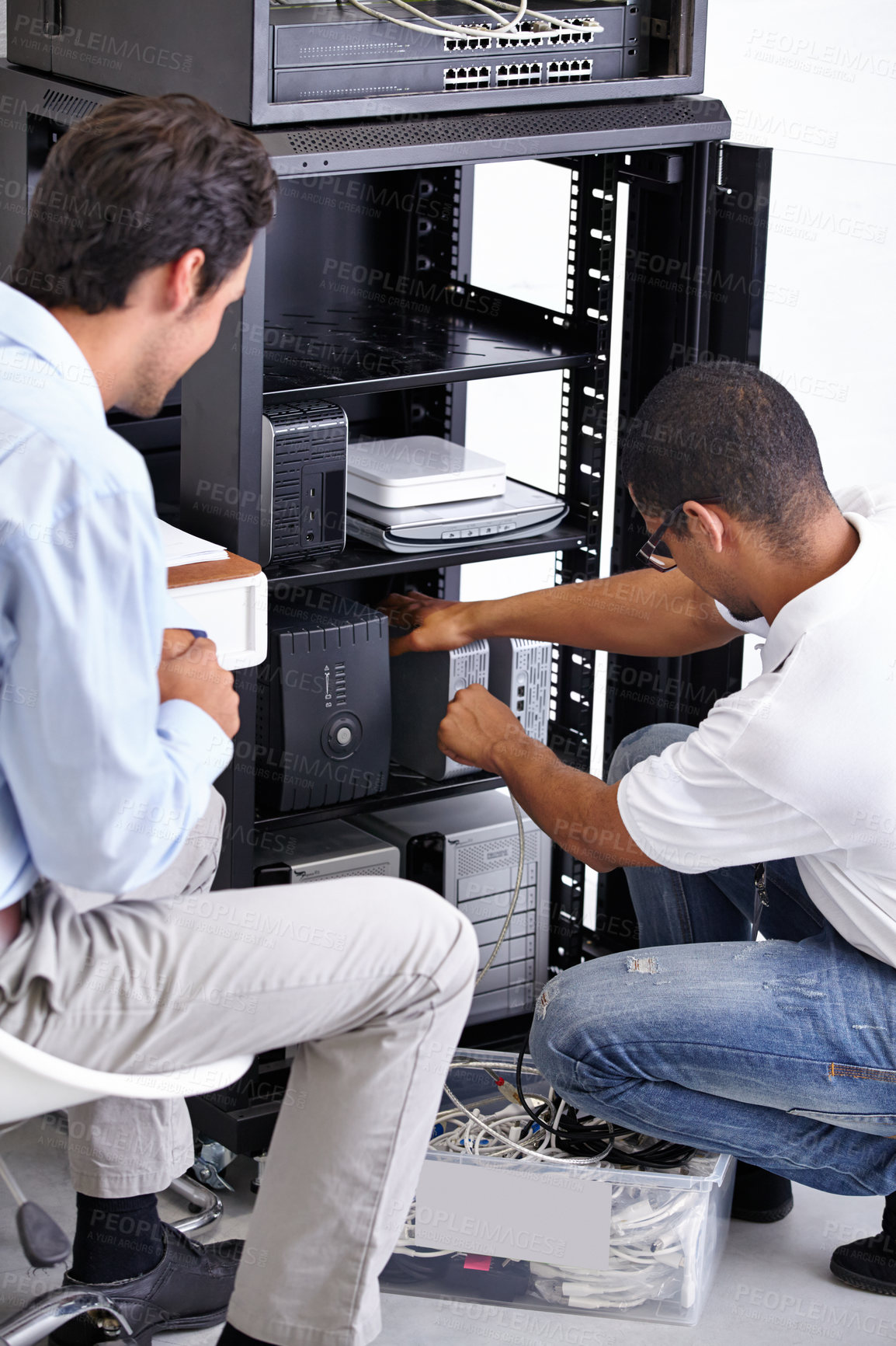 Buy stock photo Server room, man or electrician fixing electronics for hardware maintenance or working on glitch in office. IT support or worker with a technician or electrical engineer for information technology