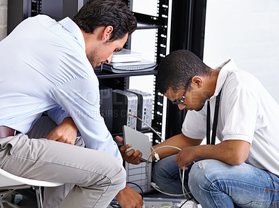Buy stock photo Two IT professionals working on a server