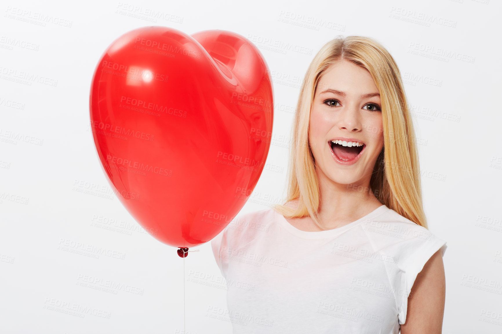 Buy stock photo A gorgeous young blonde woman holding a heart while isolated on a white background