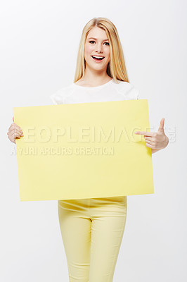 Buy stock photo A pretty young blonde woman holding a blank placard up for your copyspace