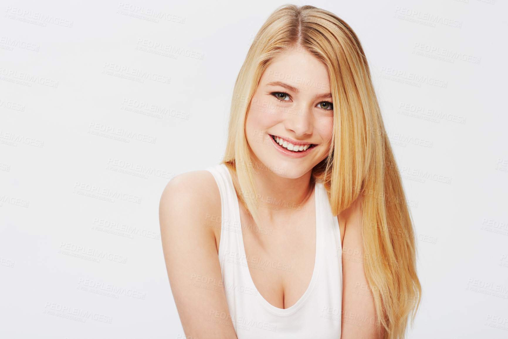 Buy stock photo A pretty young blonde sitting against a white background and looking at you