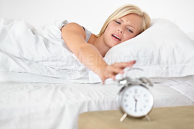 Buy stock photo Morning, wake up and alarm clock with woman in bed of home looking tired, exhausted or unhappy. Sleep, noise and fatigue with young blonde person in bedroom of apartment to snooze at start of day