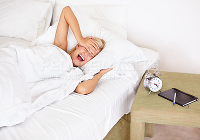 Buy stock photo Morning, alarm clock and yawn with woman waking up in bedroom of home for start of Monday. Headache, stress or fatigue and young blonde person sleeping in bed of apartment with ring for time