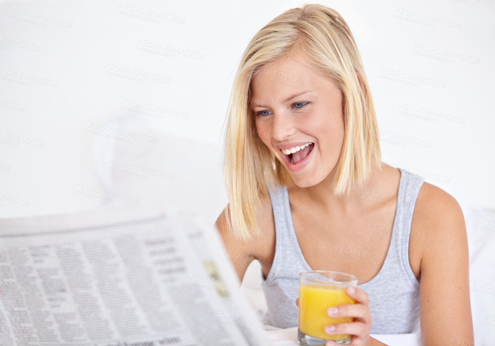 Buy stock photo Happy woman, orange juice and reading newspaper on bed for headlines, energy and health body with wellness. Blonde hair, lady and thirsty for glass of fruit drink, morning and vitamin c with smile
