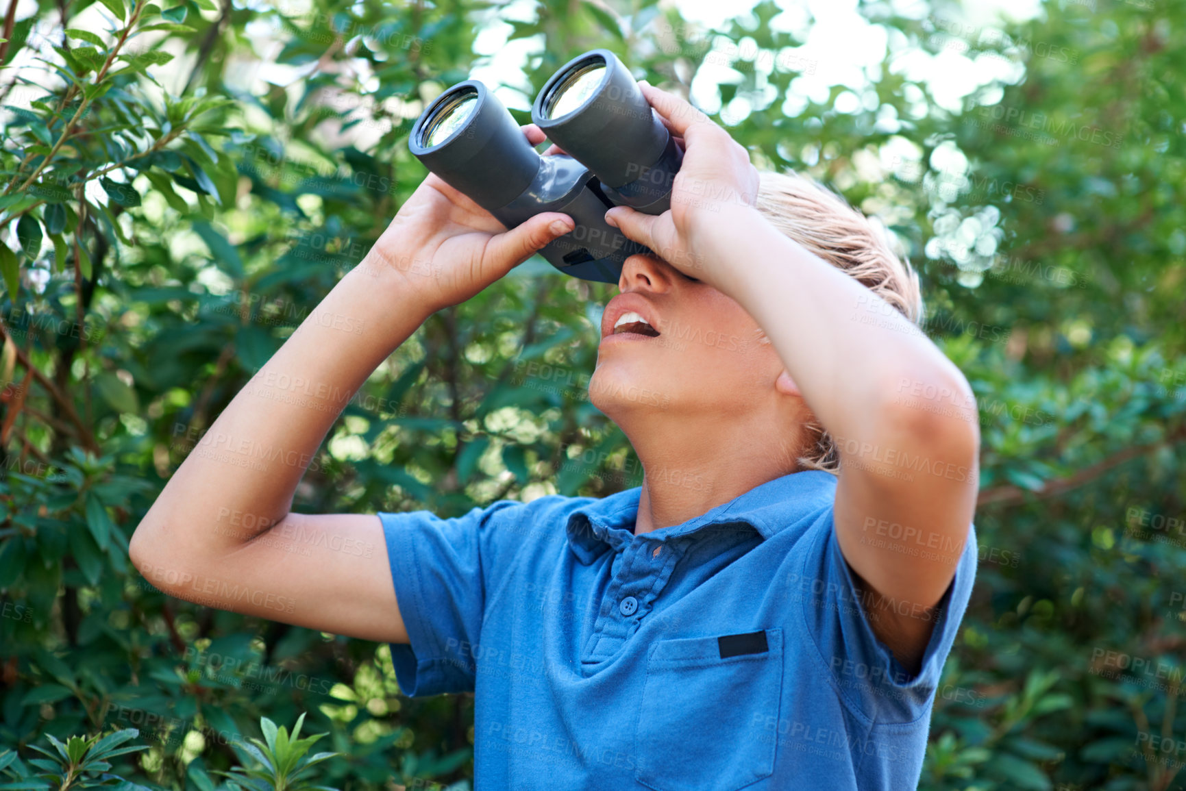 Buy stock photo Boy, child with binoculars and surprise, search in nature for learning and fun, forest and adventure at summer camp. Young camper, leaves and trees, explore environment outdoor and wow for discovery