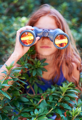 Buy stock photo Girl, kid with binoculars and search in nature for learning and fun, forest and adventure at summer camp. Young camper, leaves and explore environment outdoor in bush with hiking and discovery