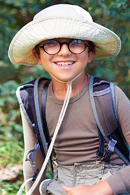 Buy stock photo Boy, kid and hiking in nature, portrait with glasses and scout outdoor for adventure, travel and fun with backpack. Discover, exploring and summer camp with happy camper in park, youth and recreation