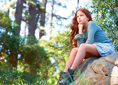 Buy stock photo Young girl, forest and thinking on rock on weekend, hike and adventure on holiday in woods for travel. Child, red hair and idea on boulder for fresh air, outdoor camping and relax wellness by trees