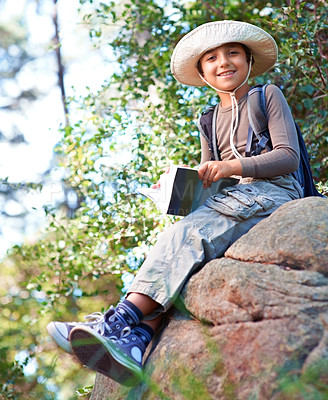 Buy stock photo Boy, kid and hiking by rock and book for reading, backpacking and adventure outdoor. Student on school field trip, relax in nature and forest for discovery or exploration, smile and travel portrait