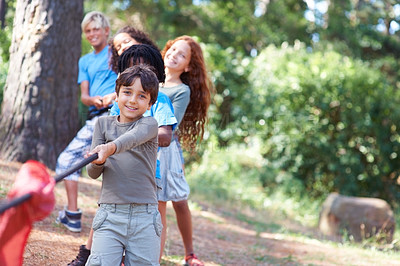Buy stock photo Children playing at tug-of-war in the woods