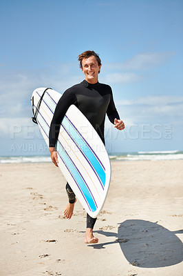 Buy stock photo A handsome surfer running down the beach with his surfboard
