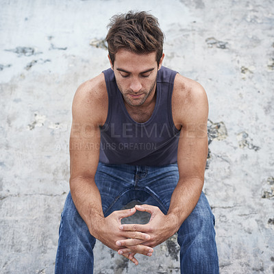 Buy stock photo A young man sitting outside