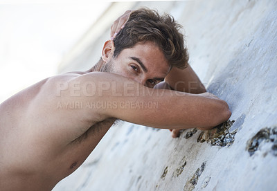 Buy stock photo Portrait of a handsome  young man leaning against a rock
