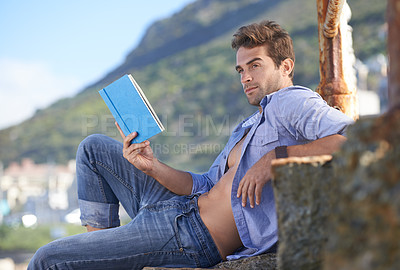 Buy stock photo Nature, book and young man reading for knowledge, fun or relaxing hobby on vacation or holiday. Travel, outdoor and handsome confident male person enjoying story or novel on weekend trip or adventure