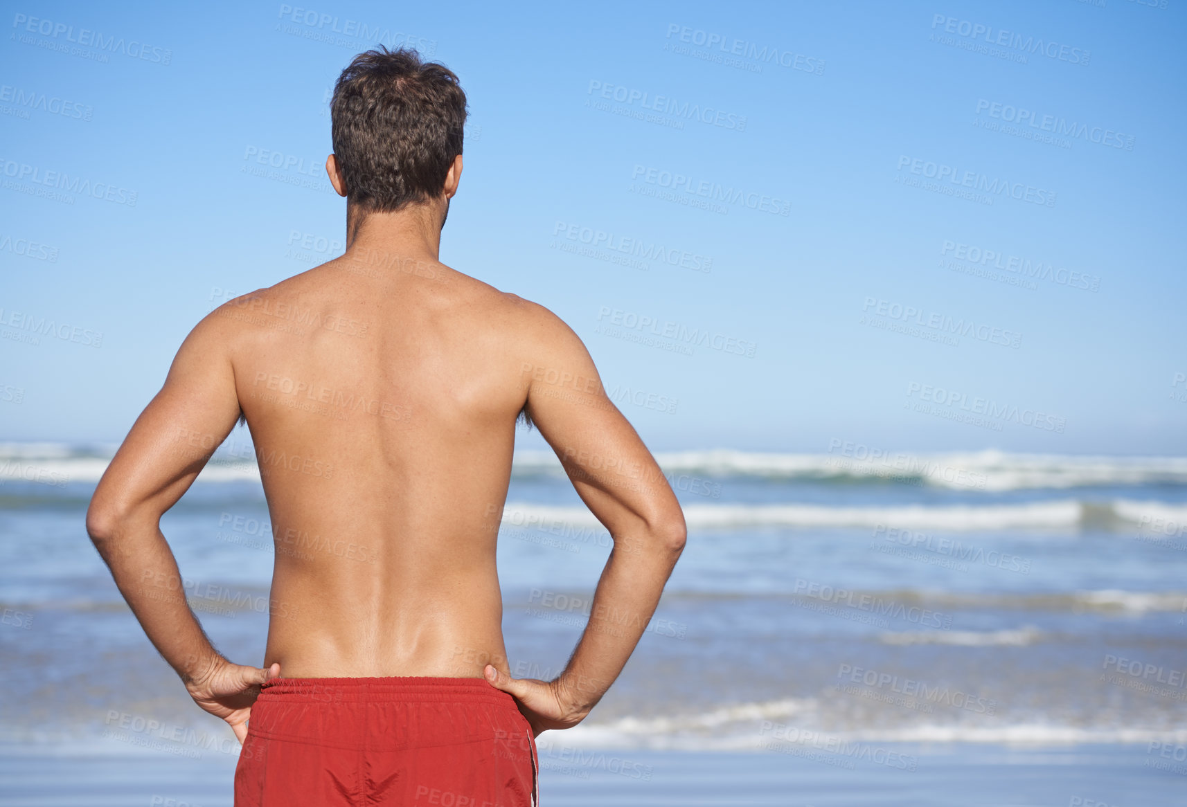 Buy stock photo Man, lifeguard and beach for security, emergency or outdoor swimming in health and safety. Rear view or back of male person or professional swimmer stranding ready for patrol at sea or ocean coast