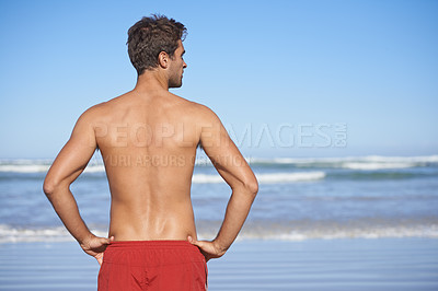Buy stock photo Rear-view of a male lifeguard looking out at the ocean