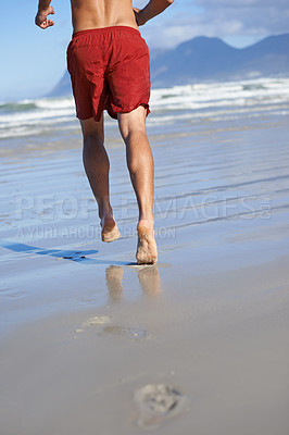 Buy stock photo Man, lifeguard and legs running on beach for security, safety and outdoor swimming emergency. Rear view or back of male person or professional swimmer ready on patrol or rescue at sea or ocean coast