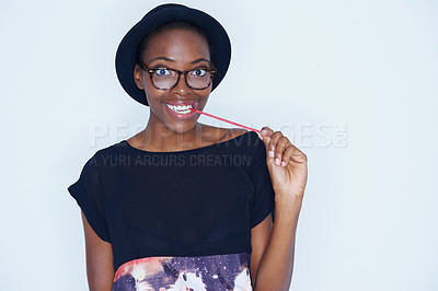 Buy stock photo Portrait, fashion and black woman eating candy in studio on white background for sugar addiction. Food, smile and happy young african person biting confectionery for hunger or craving for sweets