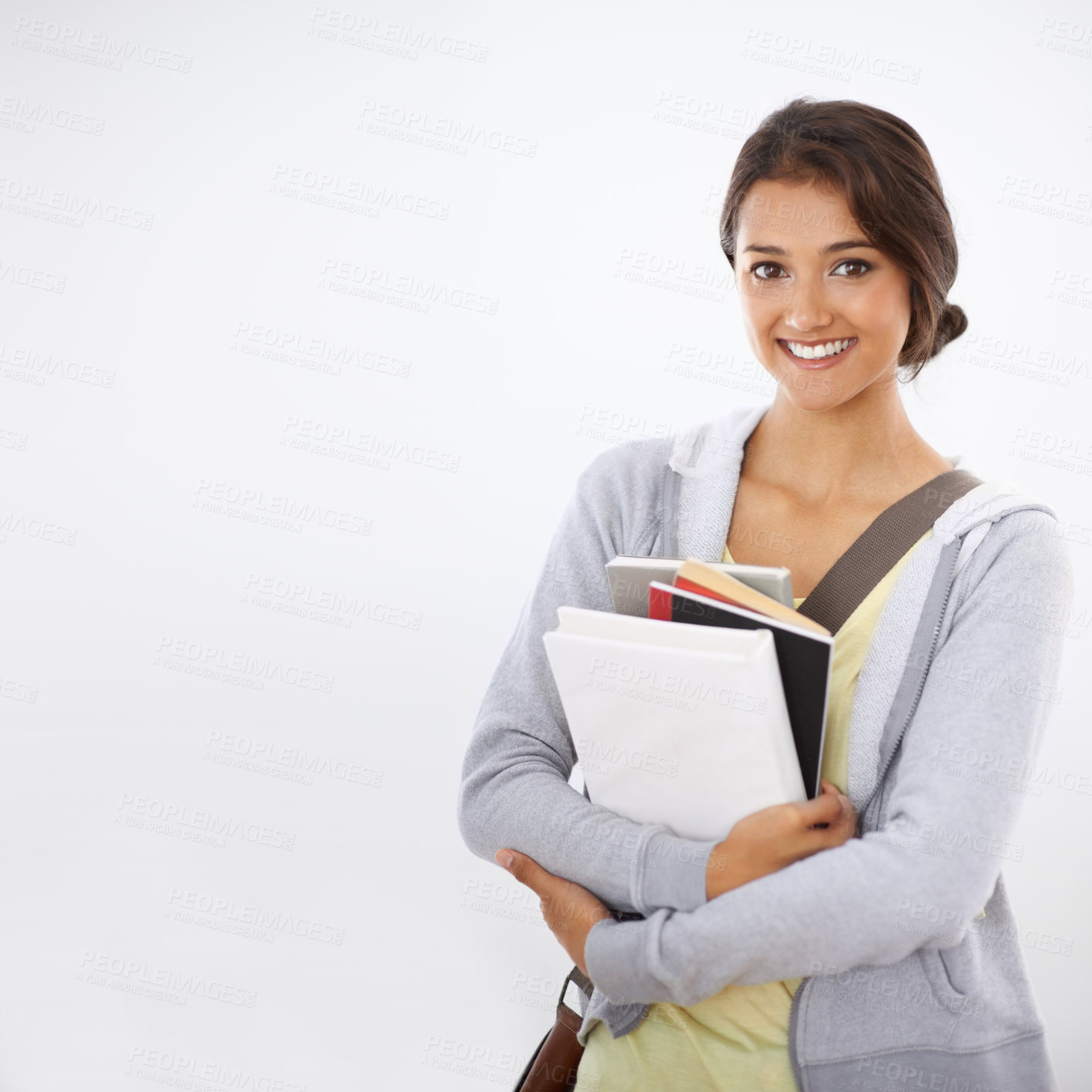 Buy stock photo Cropped studio shot of a college student smiling widely with books in her arms