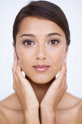 Buy stock photo A gorgeous young woman feeling her smooth, soft skin in a studio shoot