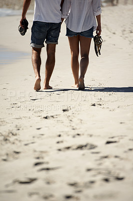 Buy stock photo Legs, holding hands and couple on beach for date, outdoor bonding love and tropical holiday. Romance, man and woman from back, walking and relax on vacation together with travel, care and adventure.