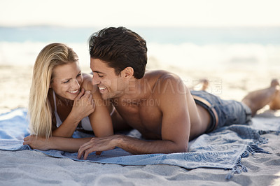 Buy stock photo Love, laughing and couple lying on beach for date, outdoor bonding or tropical holiday. Romance, man and woman at picnic, happy and relax on ocean vacation together with travel, care and adventure.