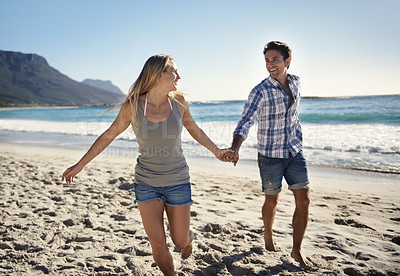 Buy stock photo Happy couple, holding hands and walk on beach, vacation and freedom in summer sunshine with bonding. Man, woman and running with smile, care and love by sand, waves and outdoor on holiday in Napoli