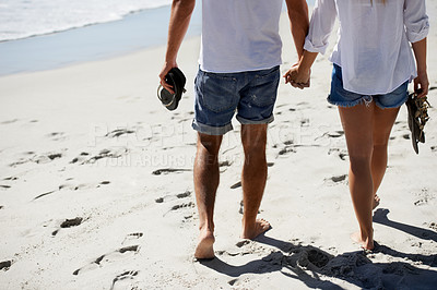 Buy stock photo Love, holding hands and couple walking on beach for date, outdoor bonding and tropical holiday. Romance, man and woman from back, legs and relax on vacation together with travel, care and adventure.