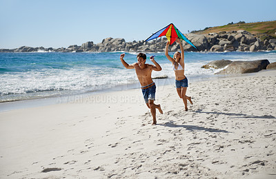 Buy stock photo Couple, running and happy with kite, beach and summer sunshine for vacation, freedom or play in air. Man, woman and happy to launch wind toys, bonding or holiday by sea for adventure in Naples, Italy