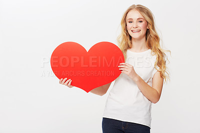 Buy stock photo Cropped view of a young woman holding a red heart in a studio